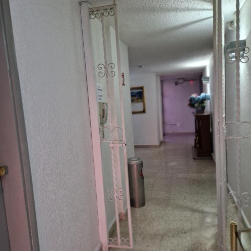 a hallway with a pink door with a trash can at Hotel polly in Mexico City