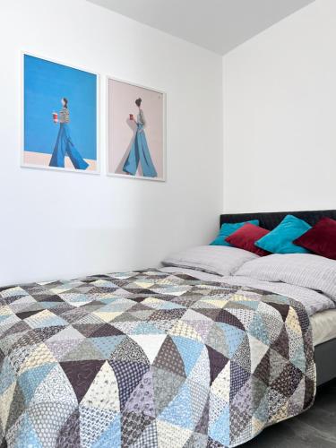a bedroom with a bed and two pictures on the wall at Sunset Studio in Kwidzyn