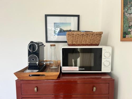 a microwave sitting on top of a wooden dresser at Self-contained ground level cottage with hill view in Edinburgh