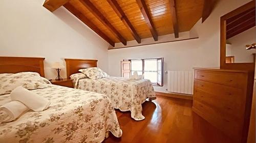 a bedroom with two beds and a window at apartamentos lleguera 1 in Llanes