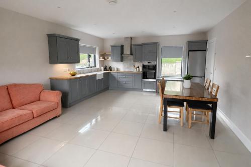 a kitchen and dining room with a table and a couch at 5 Bedroom Home Monaghan Town in Monaghan