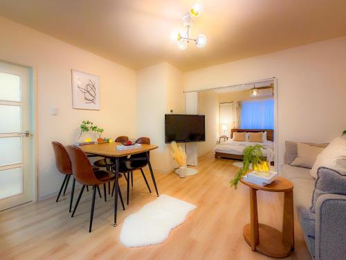 a living room with a table and a couch at Odori 601 Max 7 guests Odori Park 4m Tram 2m Subway 4m in Ōdōri