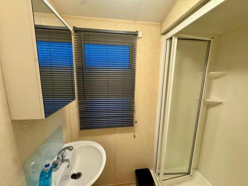 a bathroom with a sink and a shower at 8 berth pet friendly caravan, Penrhyn Bay, Llandudno in Llandudno