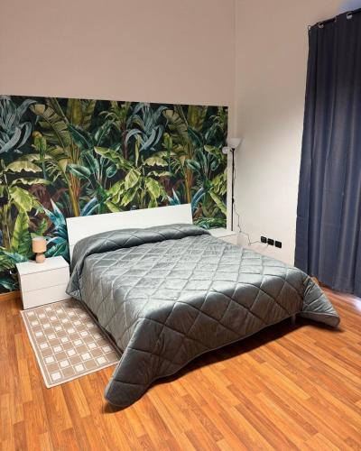 a bedroom with a large bed with a tropical wallpaper at SuiteMazzini in Lamezia Terme