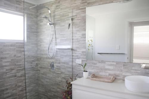 a bathroom with a shower and a sink at Enchanted Garden, 3 bedrooms in Sandstone Point