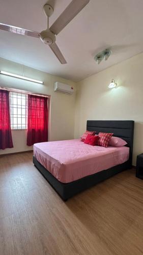 a bedroom with a bed with pink sheets and red curtains at De'Bestari Homestay in Ipoh