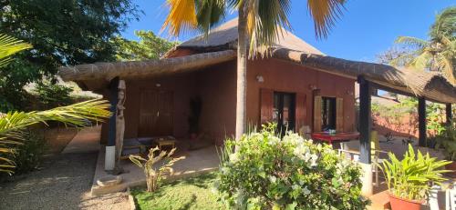una pequeña casa con techo de paja en villa de standing, en Nianing