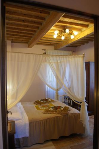 a bedroom with a bed with white curtains at La Casa del Falegname in Umbertide