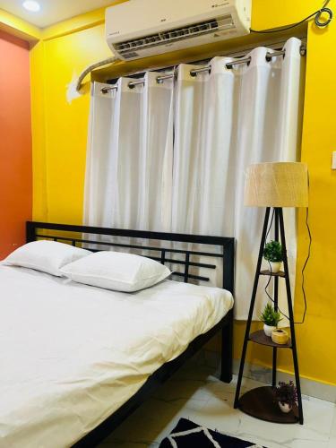 a bedroom with a bed with white curtains at House Of Green Flag VIP ROAD Baguiati Kolkata in kolkata