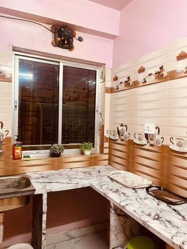 a bathroom with a marble counter and a window at House Of Green Flag VIP ROAD Baguiati Kolkata in kolkata