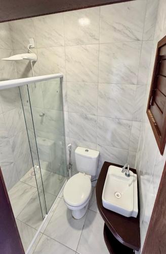 a bathroom with a toilet and a shower and a sink at Mango Village Paracuru CE in Paracuru