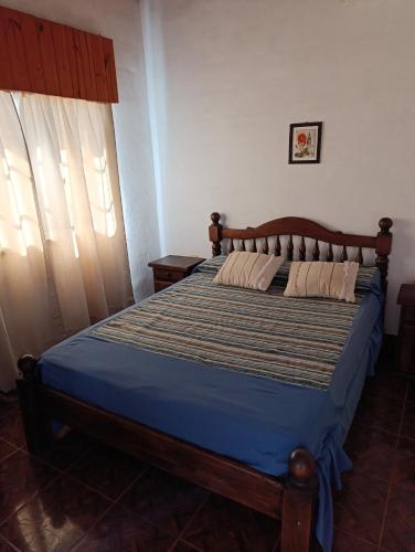 a bedroom with a bed with a blue comforter at Los Patitos Bungalows in Gualeguaychú