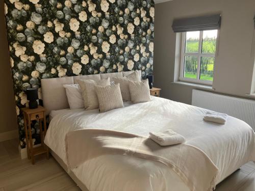 a bedroom with a white bed with a floral wall at Dannys Haven in Ballagh Cross Roads