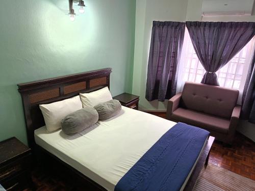 a bedroom with a bed with pillows and a chair at Macchiato Homestay - Musslim Homestay in Klang