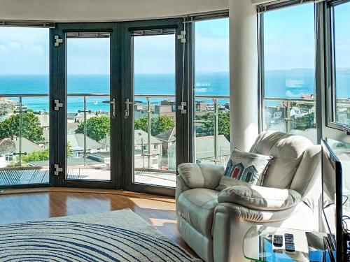 a living room with a chair and views of the ocean at 10 Horizons in Newquay