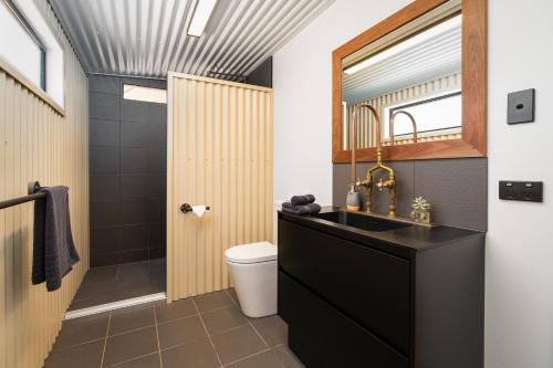 a bathroom with a black sink and a toilet at Wallaroo Outback Retreat - Glamping Tents Carnarvon Gorge in Hutton