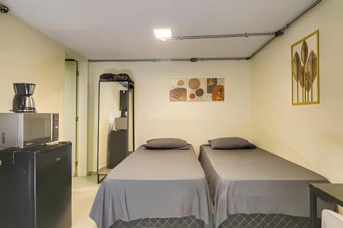a room with two beds in a room at Studio VII - Completo -Centro de Jundiaí in Jundiaí