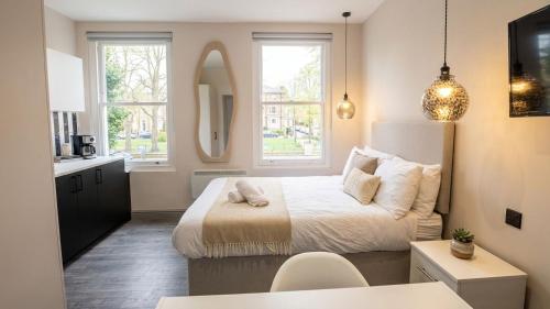 a small bedroom with a bed and a kitchen at Clapton Station Luxury Studios near Central London in London