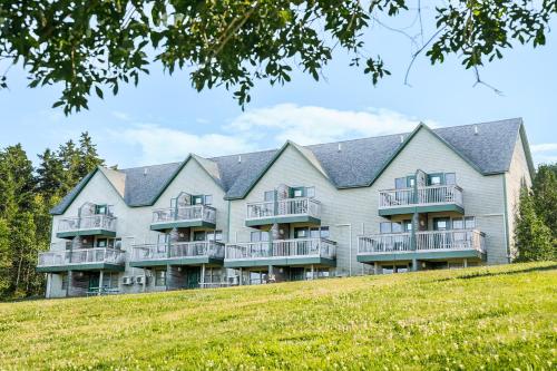 a large apartment building on a hill with a lawn at Harbor Ridge in Southwest Harbor