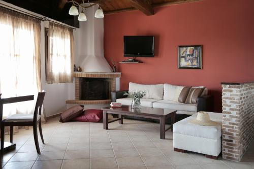 a living room with a couch and a fireplace at Yalis Hotel in Votsi