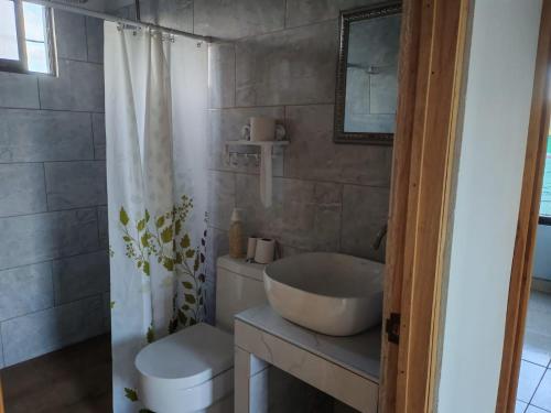 a bathroom with a white sink and a toilet at Vista Natural del Cerro in Grecia