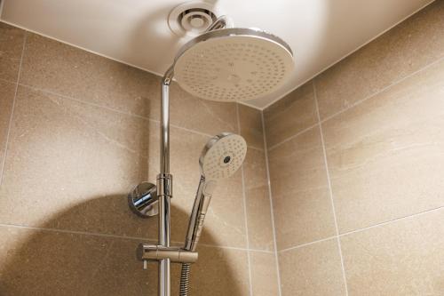 a shower with a shower head in a bathroom at HOTEL METROPOLITAN OIMACHI TRACKS Tokyo in Tokyo