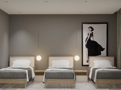 een kamer met twee bedden en een schilderij van een vrouw bij Mar' Rooftop Suites in Durrës