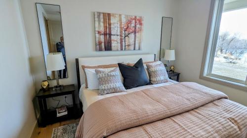 a bedroom with a bed with pillows and a mirror at Henrys Fork Suites Suite One in Saint Anthony