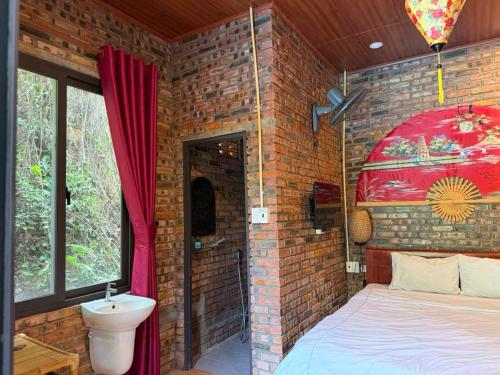 a brick walled bedroom with a bed and a sink at Sunshine villa thuy bieu in Hue