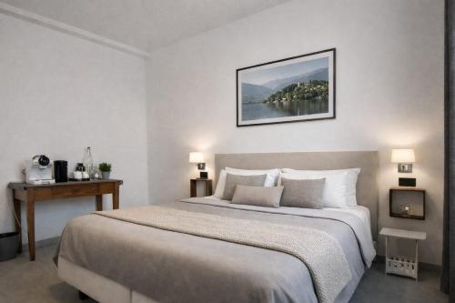 a white bedroom with a large bed and a table at BB Cadore casa vacanze in Varese