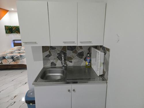 a kitchen with a sink and a microwave at Cozy renovated studio Comfort practicality in Bourgoin