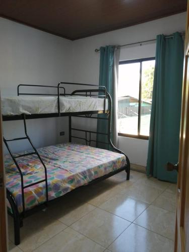 a bedroom with two bunk beds and a window at Vista Natural del Cerro in Grecia