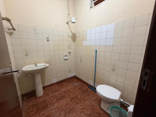 a bathroom with a toilet and a sink at Ferrari's Hotell in Miguelópolis