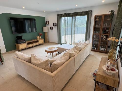 un salon avec un canapé et une télévision dans l'établissement Maison- Aude, à Cuxac-dʼAude