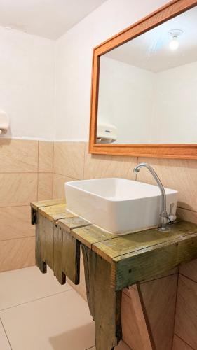 un bagno con un lavandino bianco e uno specchio di Pacific Blue a Monterrico