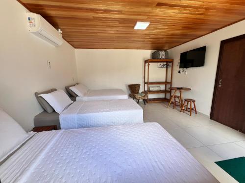 a room with two beds and a television in it at Pousada Jardim in Lauro Müller