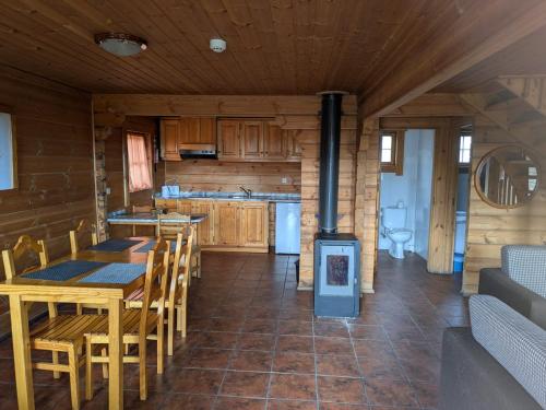 a kitchen with a table and chairs in a cabin at Chalé 24 in Penhas da Saúde