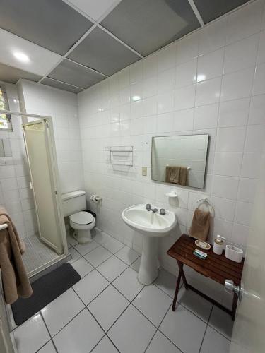 a white bathroom with a sink and a toilet at Suites Galván centro Colima, alberca, Wifi, parking in Colima