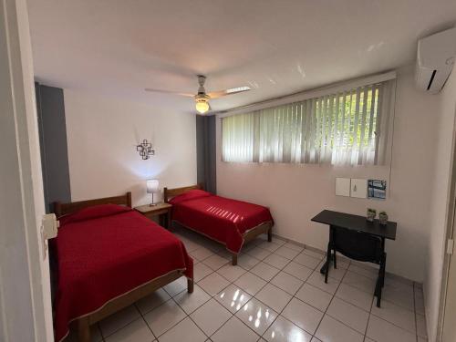 a bedroom with two beds and a table and a window at Suites Galván centro Colima, alberca, Wifi, parking in Colima