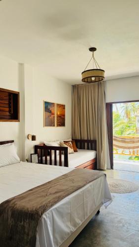a bedroom with two beds and a large window at Vila Marina Icaraizinho in Icaraí