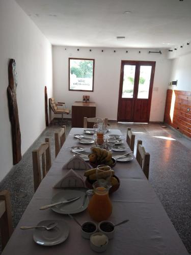 a dining room with a long table with plates and glasses at Camino del Inca in Cachí