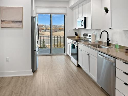 a kitchen with white cabinets and stainless steel appliances at Terrace at Two Rivers townhouse in Grand Junction