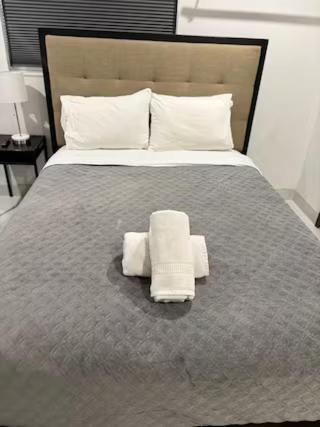 a bedroom with a large bed with towels on it at Bedroom with Bathroom 1 in Boca Raton