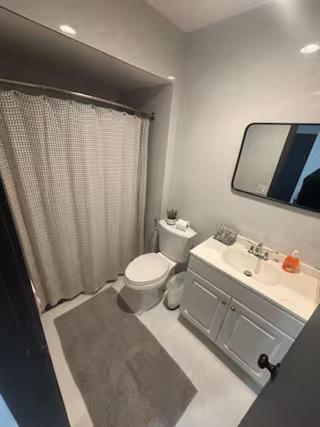 a bathroom with a toilet and a sink and a mirror at Bedroom with Bathroom 1 in Boca Raton
