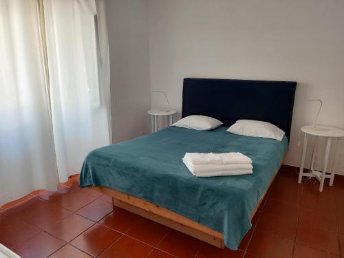 a bedroom with a bed with two towels on it at Sea Bay House in Lagoa