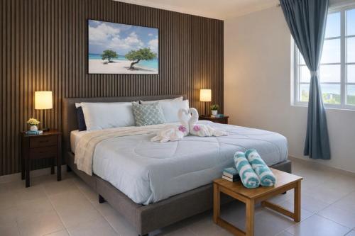 a bedroom with a bed with two stuffed animals on it at Villa Fina Aruba in Palm-Eagle Beach