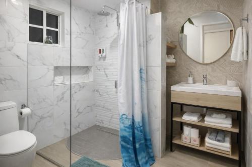 a bathroom with a shower and a toilet and a sink at Villa Fina Aruba in Palm-Eagle Beach
