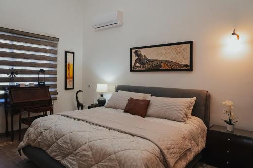 a bedroom with a bed and a desk and a piano at Casas Blancas, Planta Baja in Todos Santos
