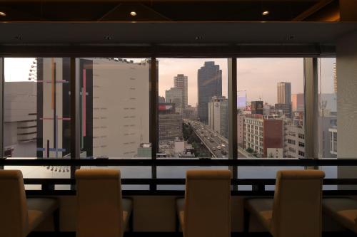 a view of a city skyline from a window at Via Inn Umeda in Osaka