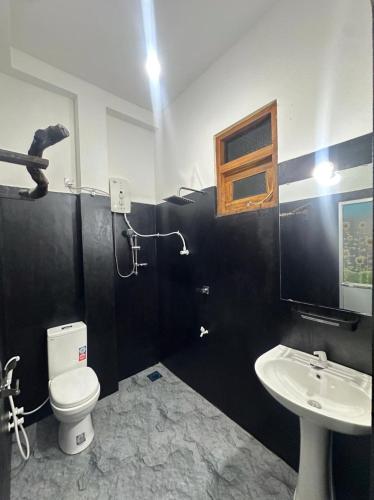 a bathroom with a toilet and a sink at Tuskers edge Retreat in Udawalawe